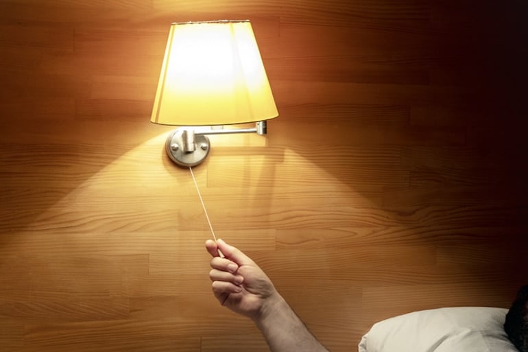 Doctor turning off light in bed to ensure he gets enough sleep to stay healthy and boost immunity