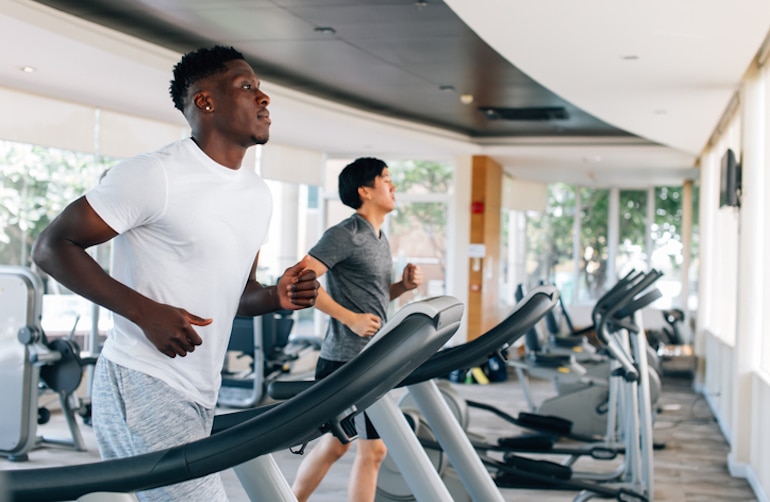 Two men running on treadmills at the gym to support the immune system