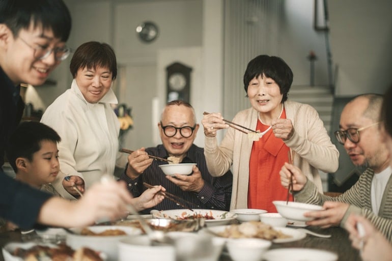 Asian family with seniors eating dinner to benefit from human connection, family ties, and healthy eating habits