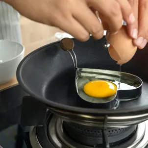 Person cooking egg in a heart-shaped block to illustrate how nutrition affects mental health