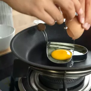 Person cooking egg in a heart-shaped block to illustrate how nutrition affects mental health