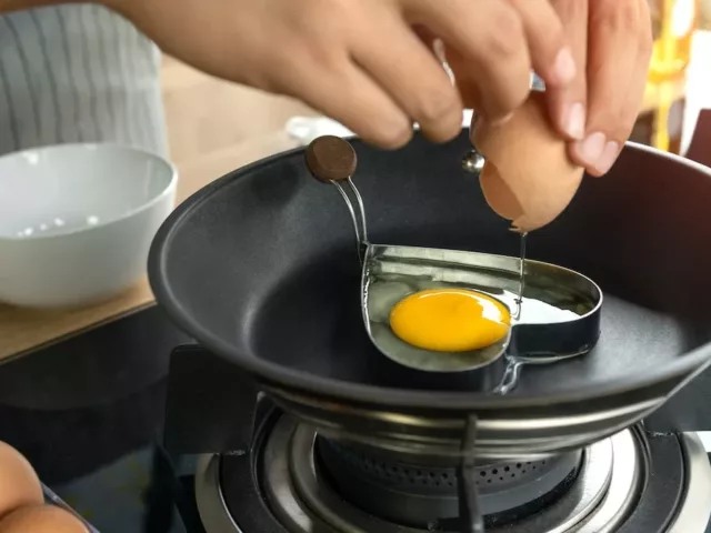 Person cooking egg in a heart-shaped block to illustrate how nutrition affects mental health