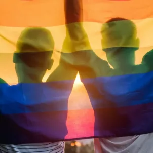 Two men holding a rainbow flag to celebrate pride; recognized LGBTQ+ beauty and wellness brands in Los Angeles