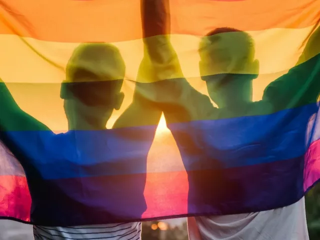 Two men holding a rainbow flag to celebrate pride; recognized LGBTQ+ beauty and wellness brands in Los Angeles