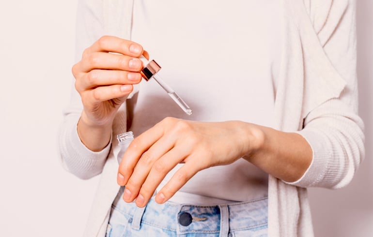 Woman applying the best anti-pollution serum