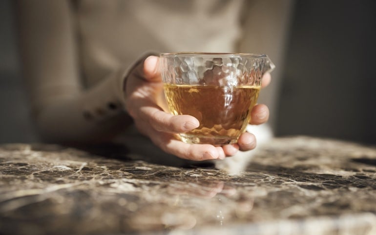 Woman sipping green tea as a healthy alternative to energy drinks