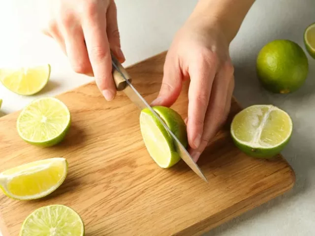 Woman slicing limes for a vinaigrette recipe