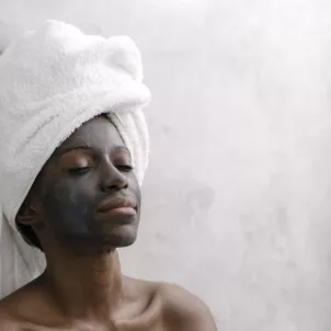 Woman relaxing while benefiting from activated charcoal skincare products