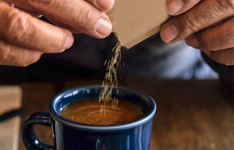 Man pouring Sugar in the Raw into a cup of coffee