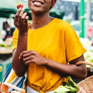 Black woman shopping at farmers market for fresh produce