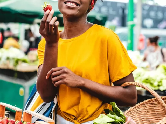 Black woman shopping at farmers market for fresh produce