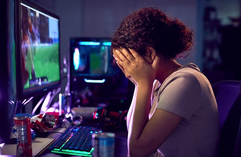 Teenage girl at computer crashing after consuming too many energy drinks