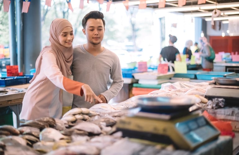 Couple at fishmonger buying fresh fish