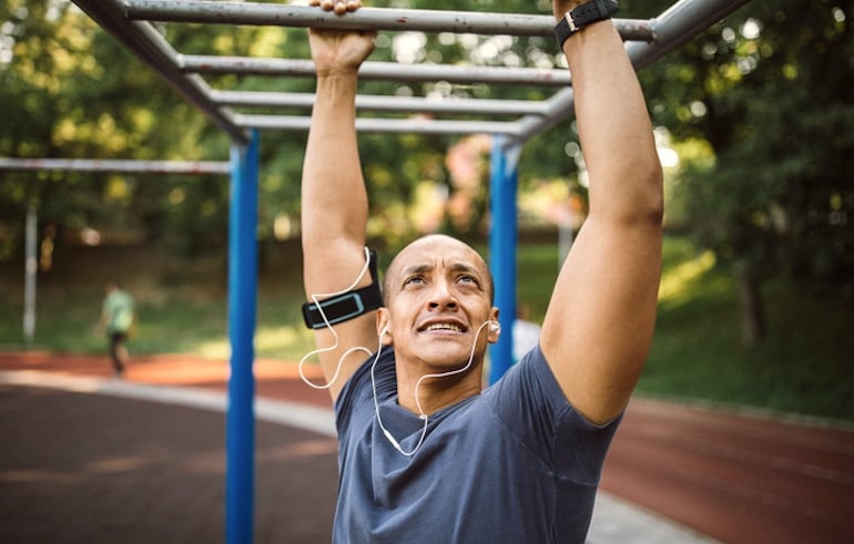 Man exercising in jungle gym after work in the early evening