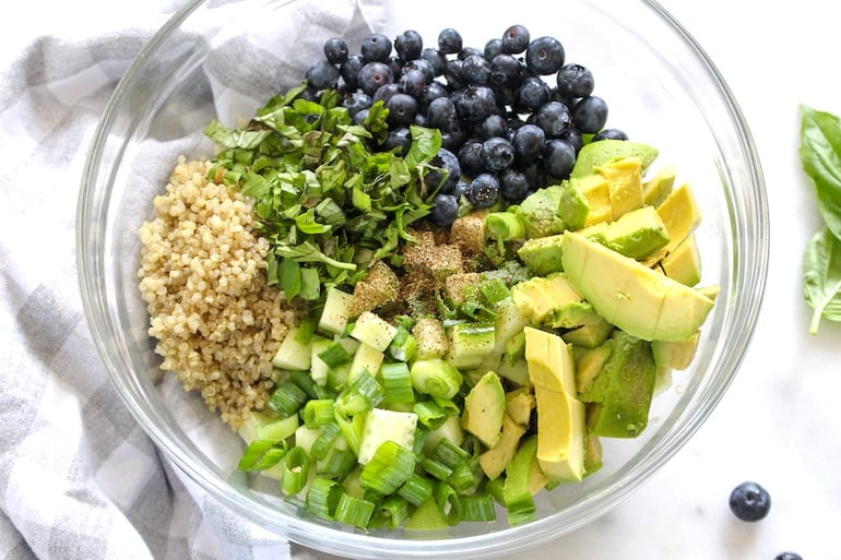 Quinoa, cucumbers, blueberries, avocado, and other veggies in a healthy summer quinoa salad