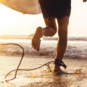 Man going surfing at sunrise