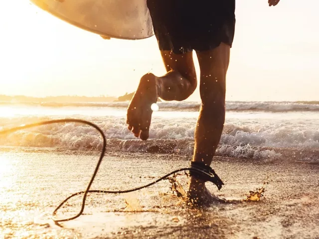 Man going surfing at sunrise