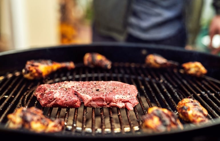 Well-oiled and salted BBQ meats on a charcoal grill