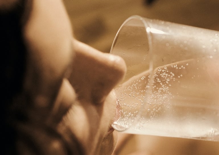 Woman drinking seltzer to stay hydrated