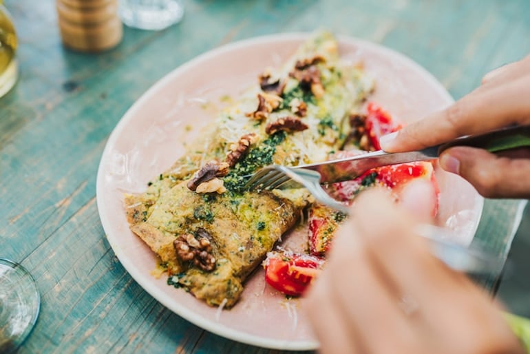 Man cutting into omelette made with organic free-range eggs