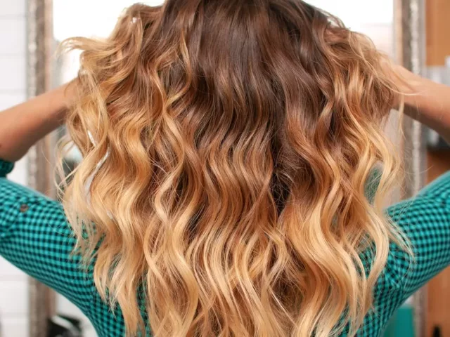 Woman with perfect beach waves running hands through her hair