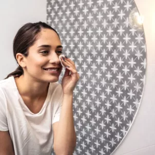 Woman exfoliating by applying PHA toner