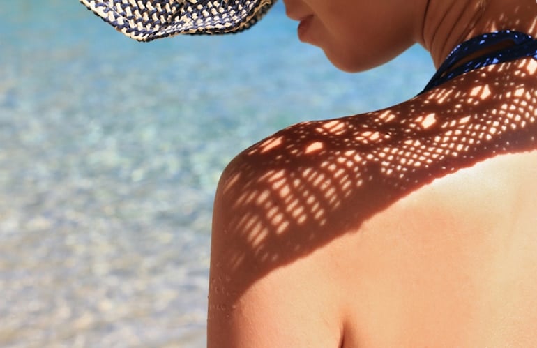 Woman wearing a straw hat for photoprotection