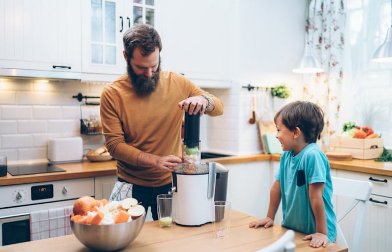 Father and son juicing in the kitchen