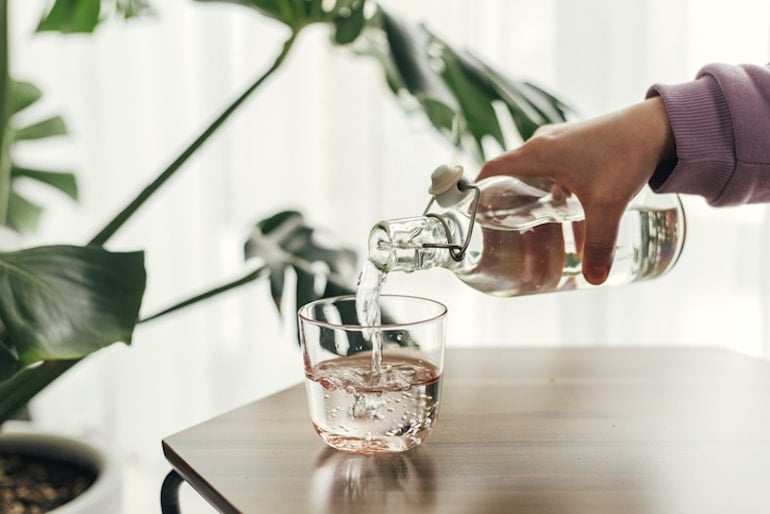 Pouring filtered tap water into a glass 