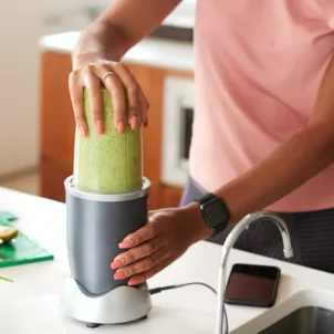 Woman making a green smoothie for their health benefits
