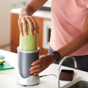 Woman making a green smoothie for their health benefits