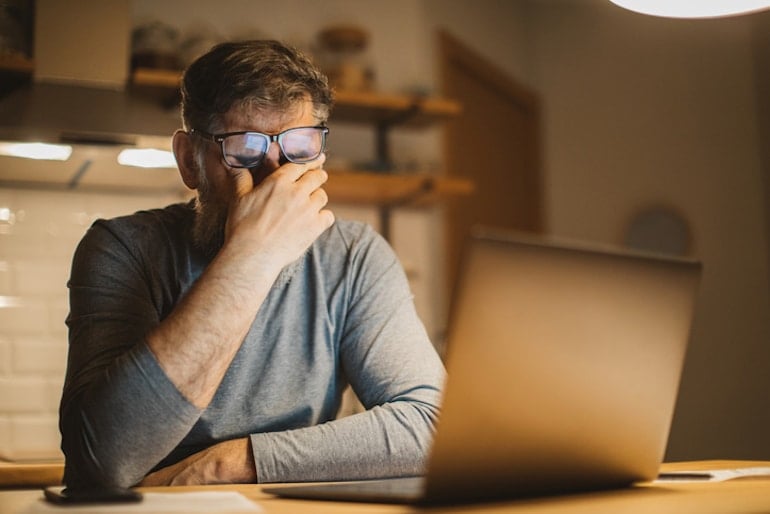 Stressed man working late at night and not getting enough sleep