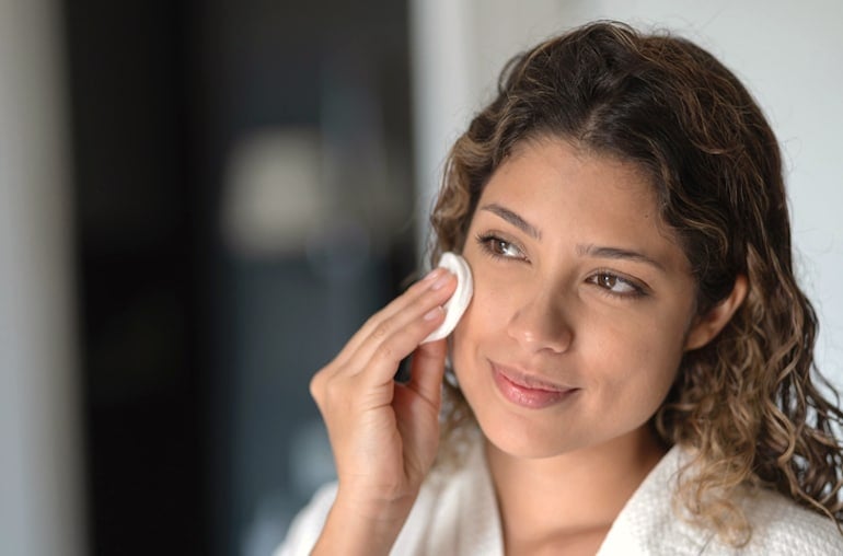 Woman applying topical probiotic toner with fermented ingredients for clear skin