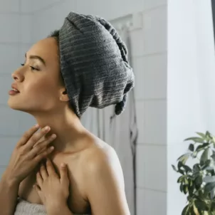 Woman out of shower looking at her complexion after using probiotic skincare