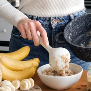 Woman preparing oats and fruit for a low FODMAP breakfast