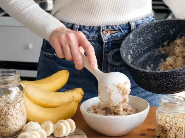 Woman preparing oats and fruit for a low FODMAP breakfast