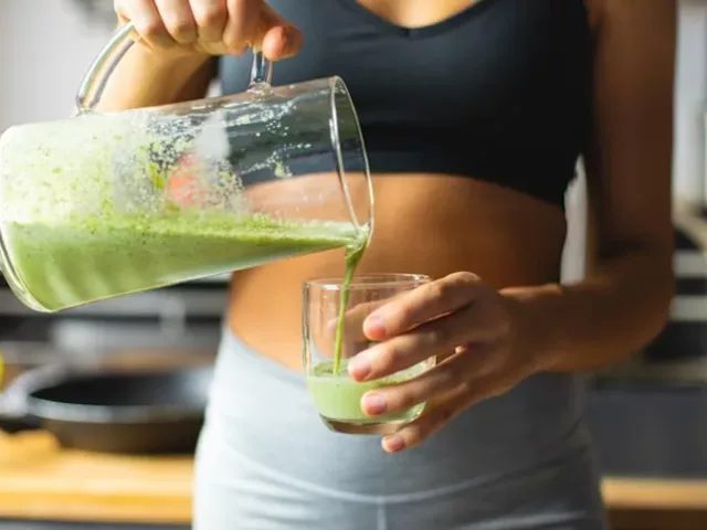 Athletic woman pouring a low FODMAP vitamin C smoothie for breakfast