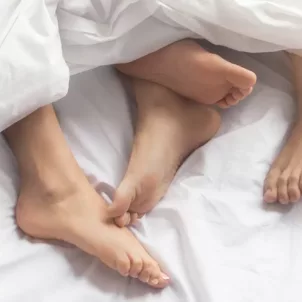 two pairs of feet in sheets