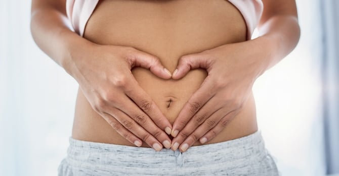 woman with hands on stomach