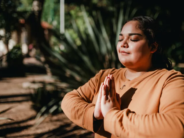 Woman meditating outdoors; calm and stress-free thanks to the benefits of L-theanine