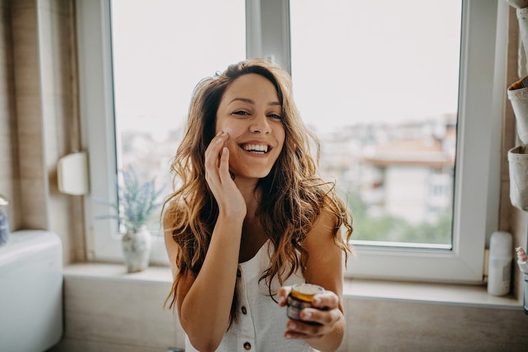 woman applies cream