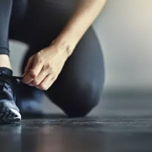 woman at gym tying sneaker