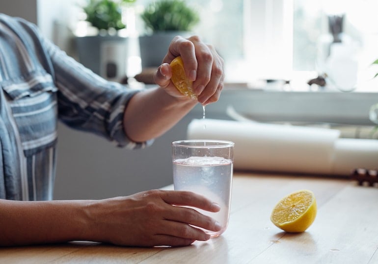 vrouw die citroenwater maakt