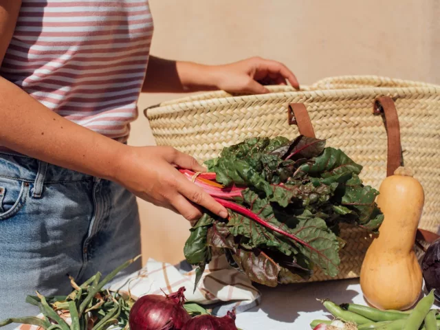 Woman unpacking fresh fruit and vegetables to store in her kitchen