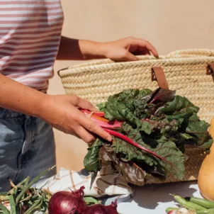 Woman unpacking fresh fruit and vegetables to store in her kitchen