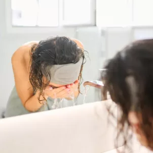 Woman washing face with gentle cleanser to embrace skinimalism