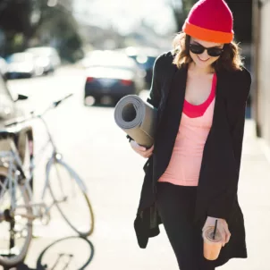 Woman walking out of yoga with a smoothie to illustrate the 70/30 diet and exercise plan