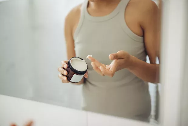 Woman applying moisturizer for her minimalist skincare routine