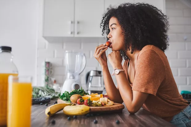 Woman eating berries during ovulation to support her cycle syncing diet