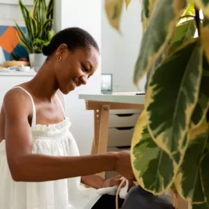 Woman spring cleaning her house plants to benefit mental health